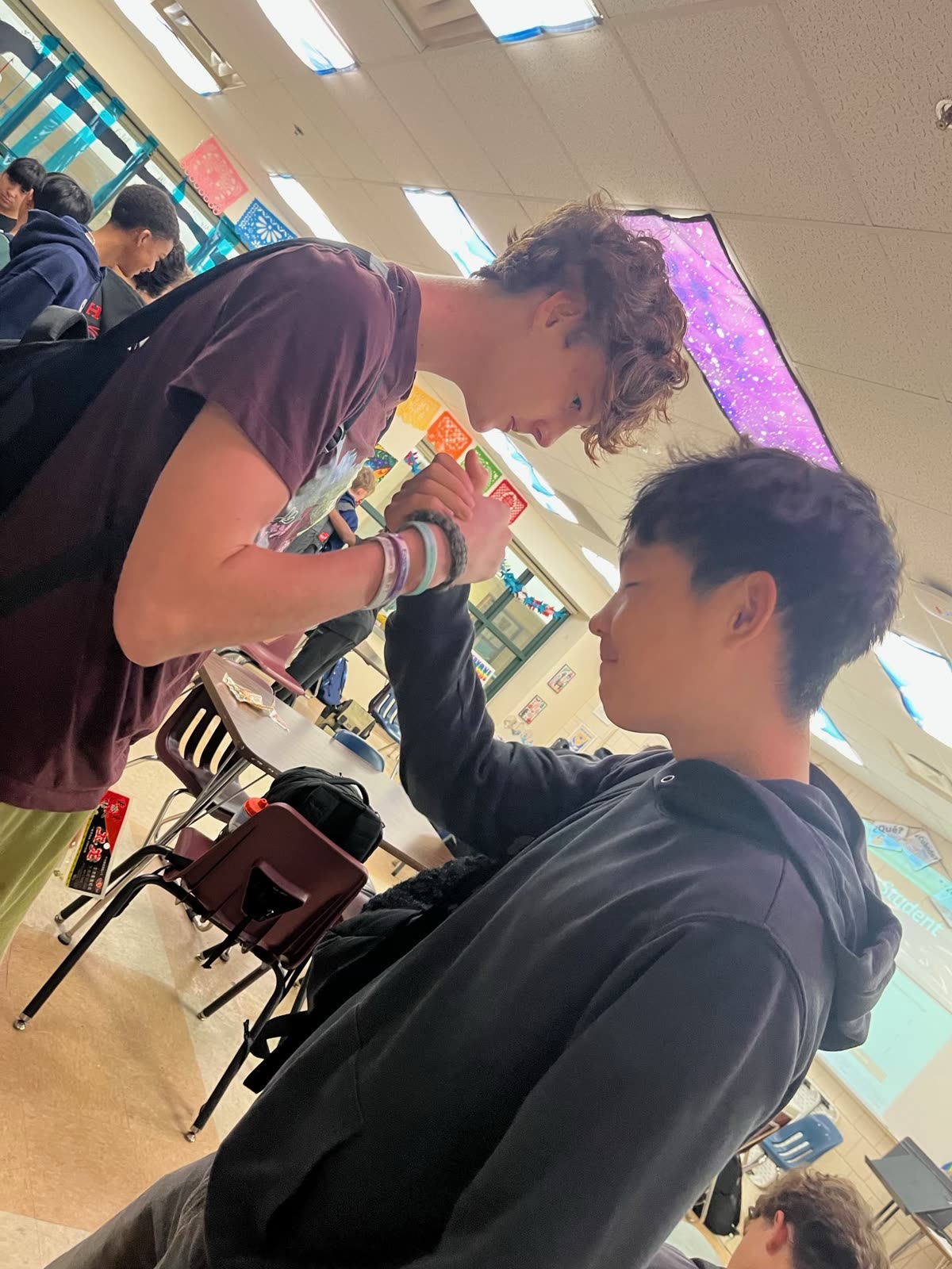 Two students clasping hands at a meeting