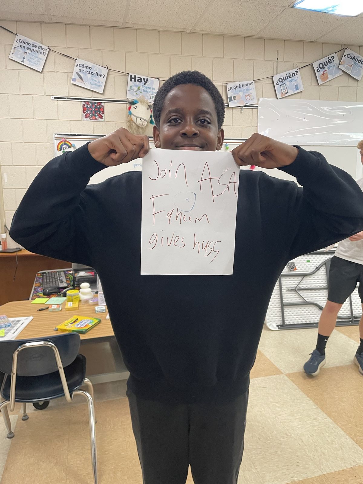 A student holding a "Join ASA" poster